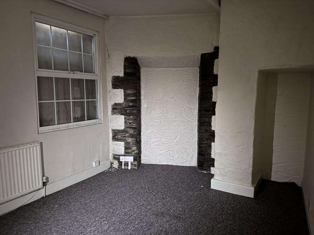 Lot: 9 - TOWN CENTRE BUILDING ARRANGED AS THIRTEEN FLATS IN NEED OF SIGNIFICANT IMPROVEMENT - Part of the living room in one of the flats